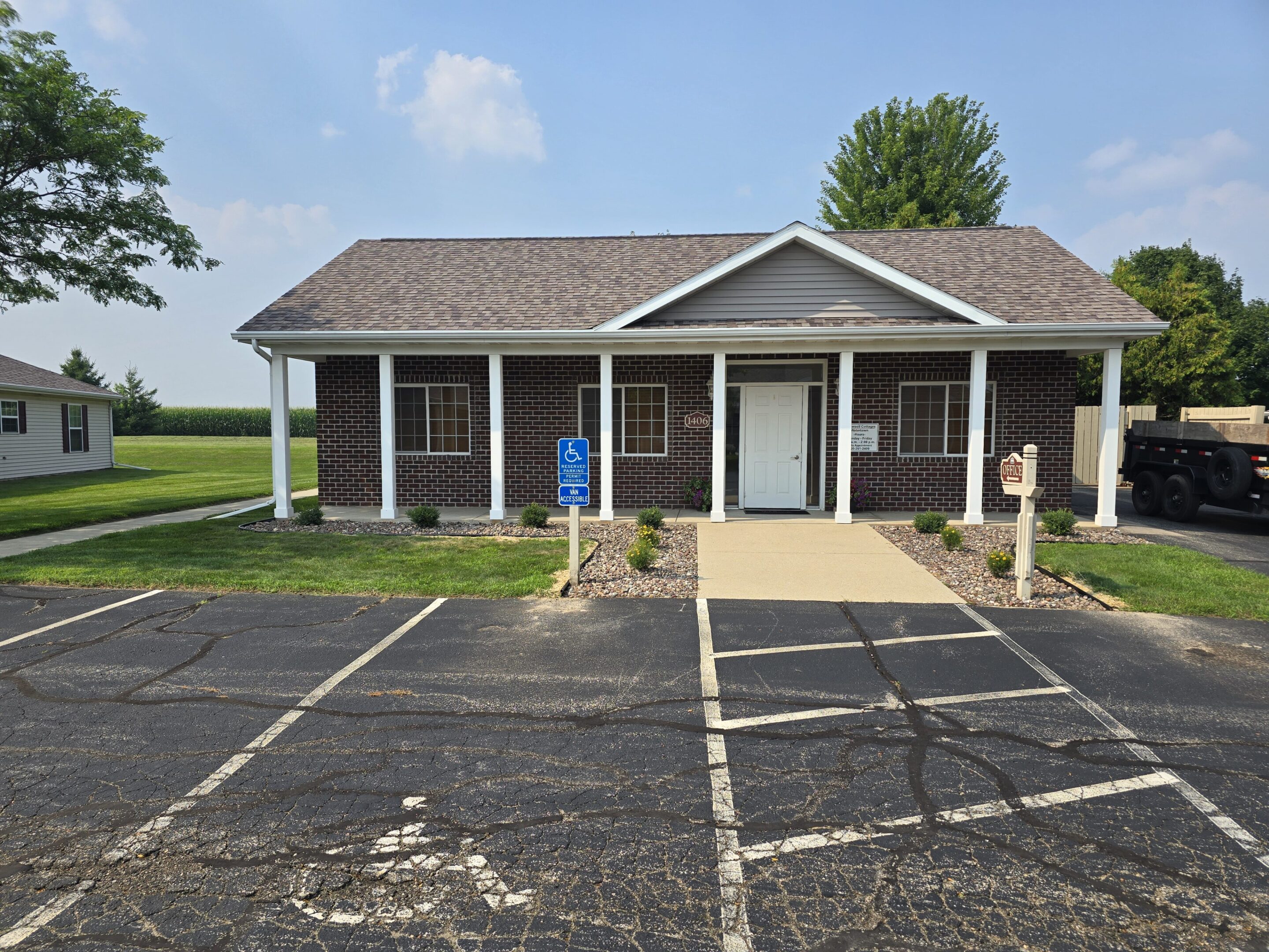 Small rustic brick building with a shingled roof and a simple entrance.