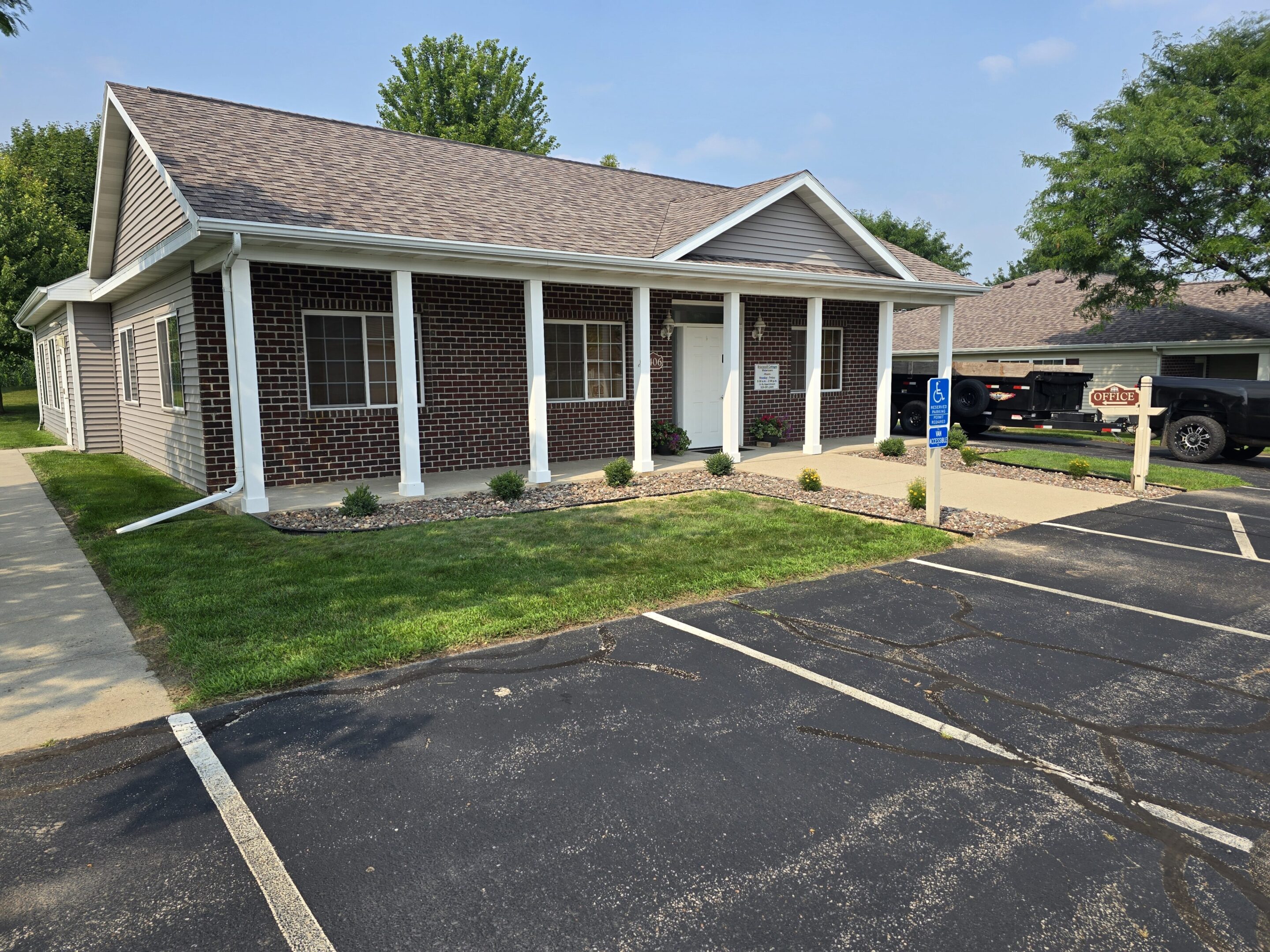 A small brick building with white columns and a tiled roof.