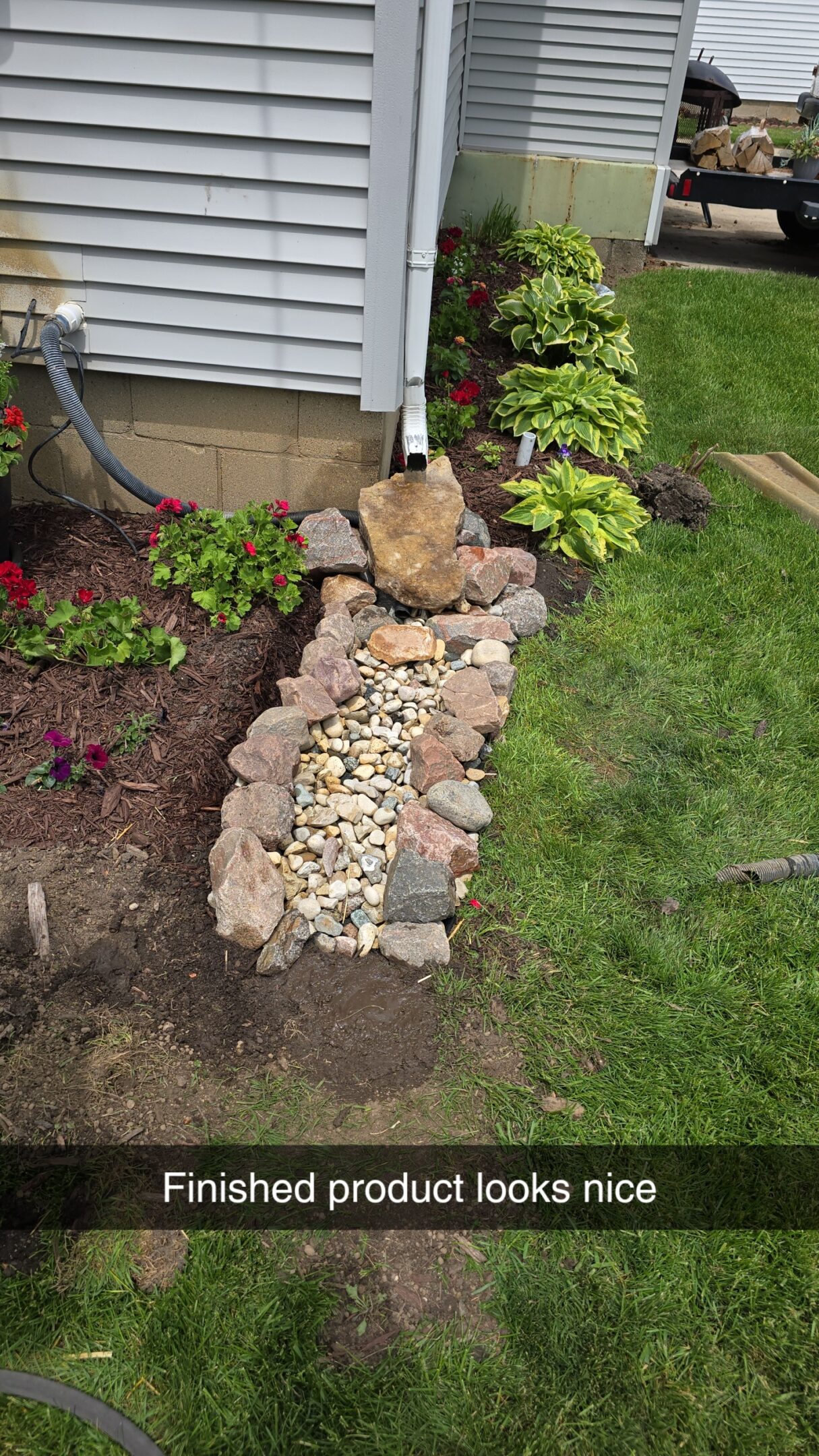 A small garden rock pathway bordered by plants and soil.
